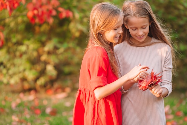 Little adorable girls outdoors at warm sunny autumn day