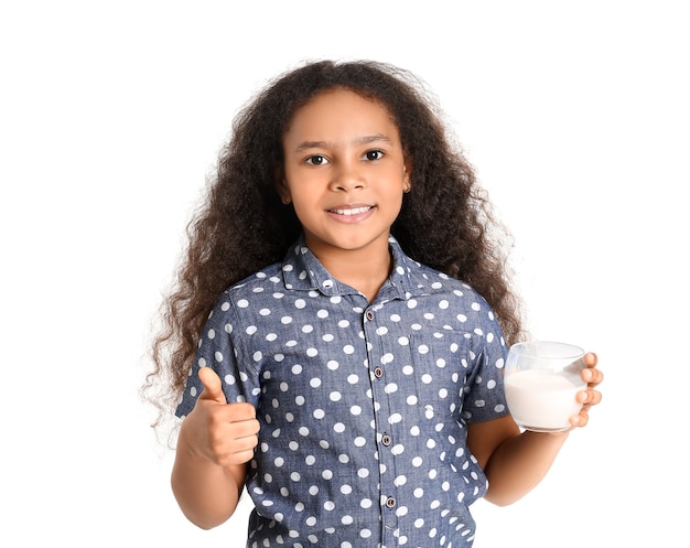 Little African-American girl with milk showing thumb-up on white