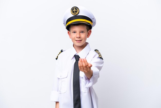 Little airplane pilot boy isolated on white background inviting to come with hand Happy that you came