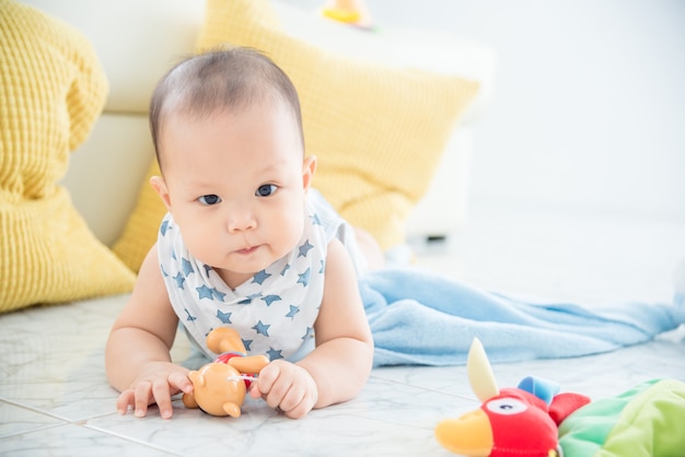 Little asian cute boy laying on the floor and looking at camera.