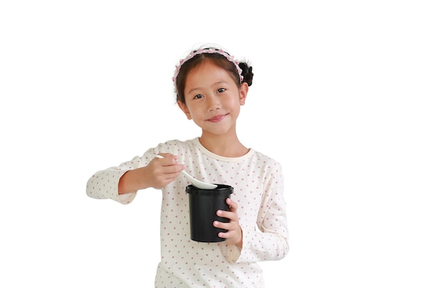 Little Asian girl child eating food from black cup isolated on white background Food and advertising concept