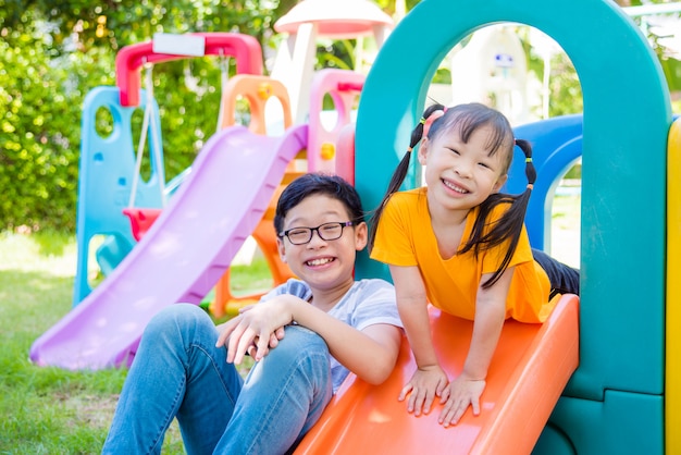 Little asian girl and her brother playing at school playground