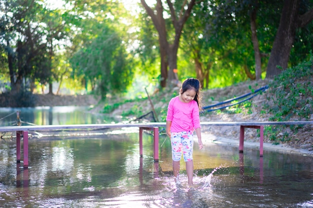 Little asian girl playing water in the park on holiday