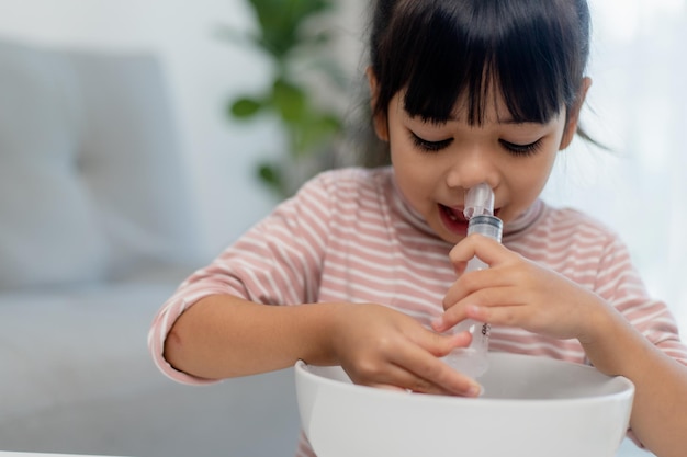 Little asian girl saline nasal wash nose at home