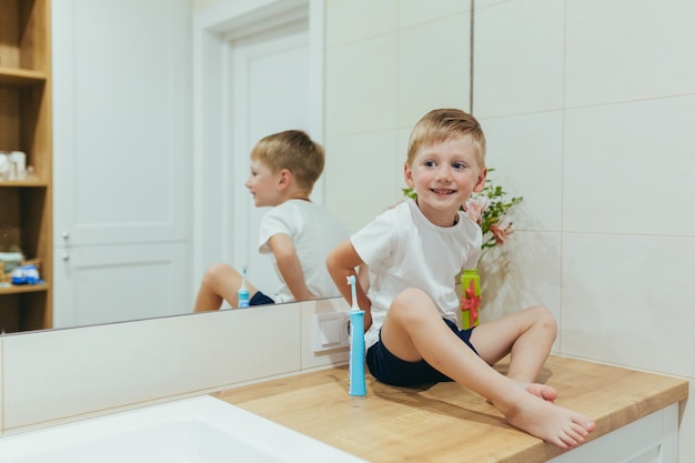 Little baby boy learns to brush his teeth in the bathroom