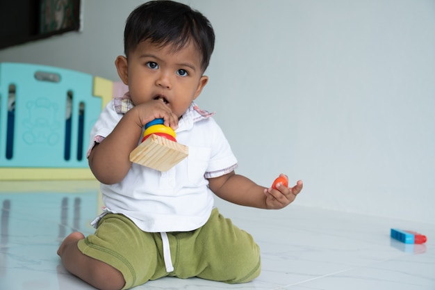 Little baby boy play wooden toy at room