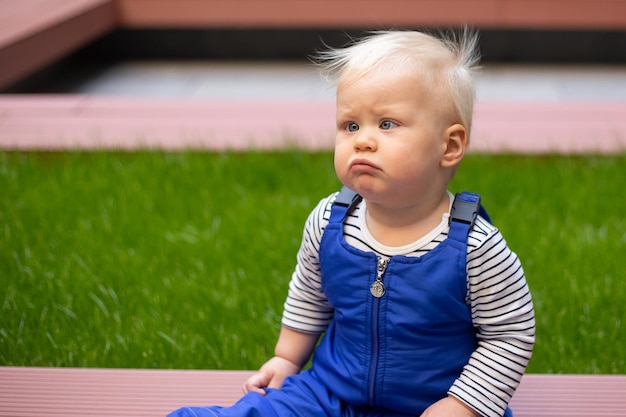 Little baby boy portrait of child outdoor with strabismus eyes