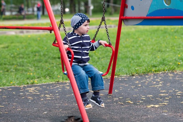 Little baby boy riding on a swing