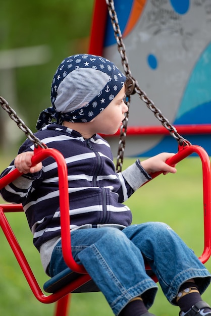 Little baby boy riding on a swing