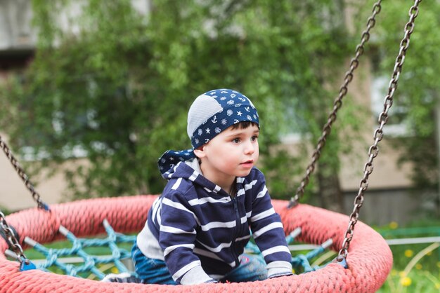 Little baby boy riding on a swing