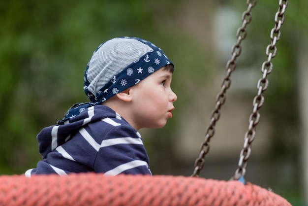 Little baby boy riding on a swing