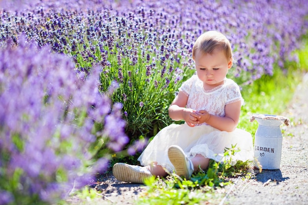 Little baby girl in a lavender field in summer park