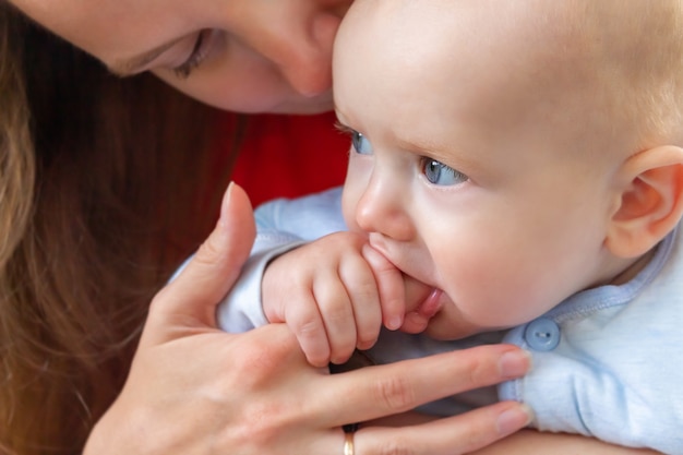 Little baby holding mothers finger in mouth