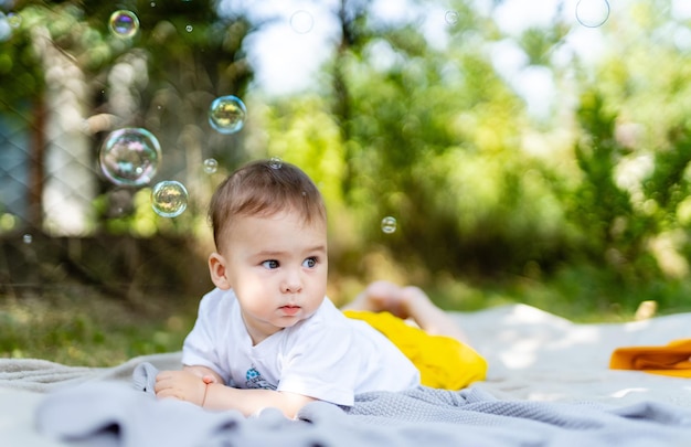 Little baby playing on a blanket in the park on a sunny day Real life shot of a baby Outdoor fun for children