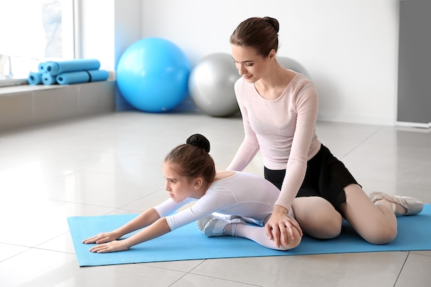 Little ballerina training with coach in dance studio