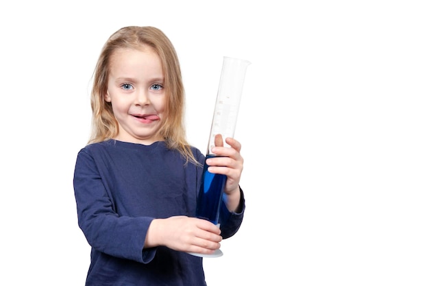 little beautiful girl stuck out her tongue and holds a test tube with blue liquid in her hands isolated on white background