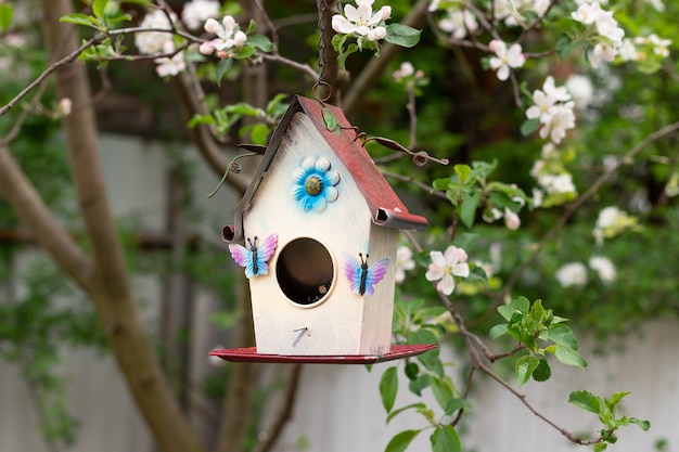 Little birdhouse in spring over a blossoming apple tree. spring time nature