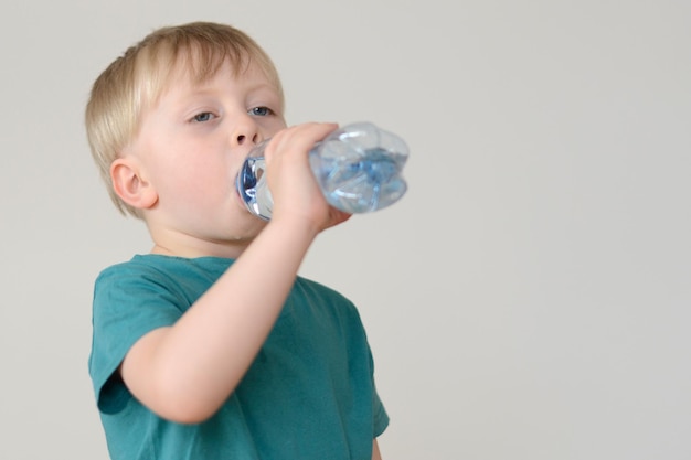 little blond boy drinks water