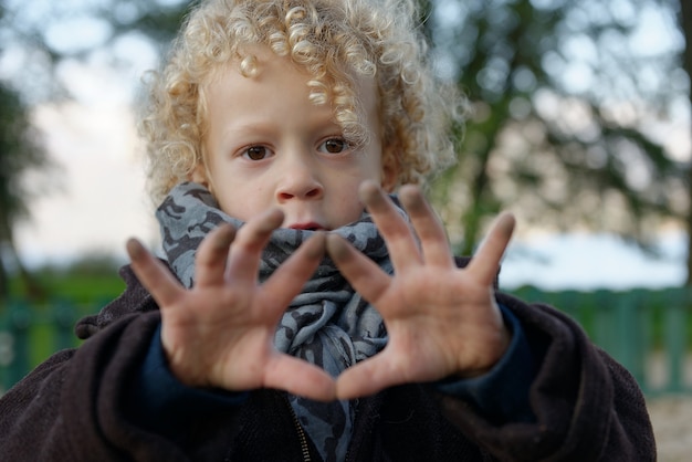 Little blond boy showing his hands dirty