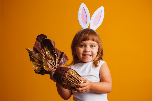 Little blond girl with bunny ears and easter egg