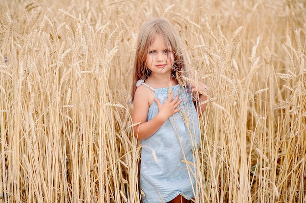 Little blonde girl in the wheat field