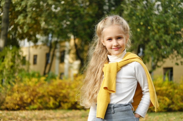 Little blonde preschool girl in jeans turtleneck and sweater