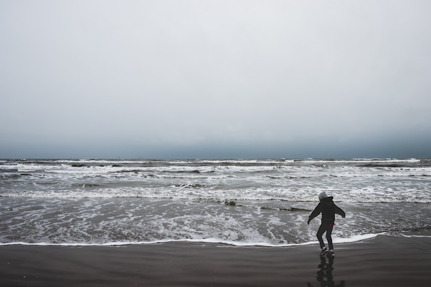 A little boy alone by the ocean