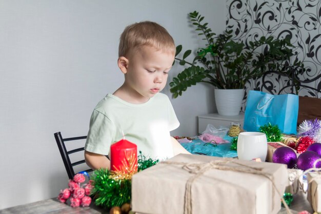 A little boy in anticipation of christmas and new year playing with christmas decorations witing for