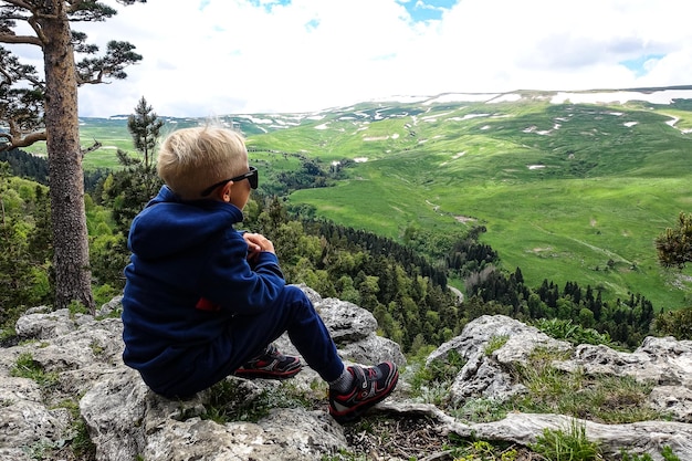 A little boy on the background of the alpine meadows of the LagoNaki plateau in Adygea Russia 2021