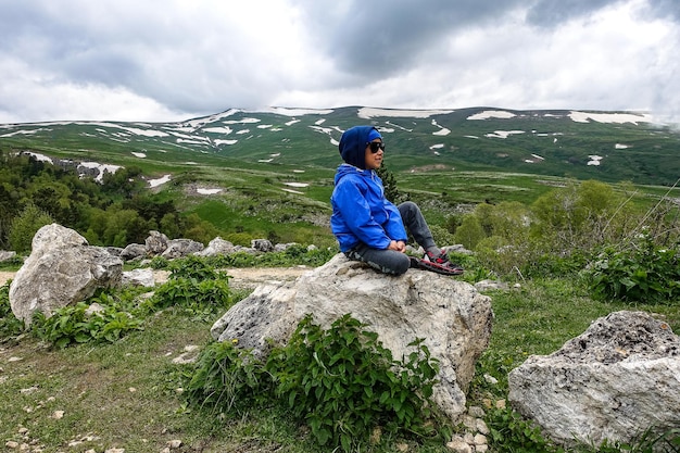 A little boy on the background of the alpine meadows of the LagoNaki plateau in Adygea Russia 2021