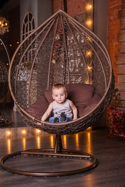 Little boy in a big cocoon chair