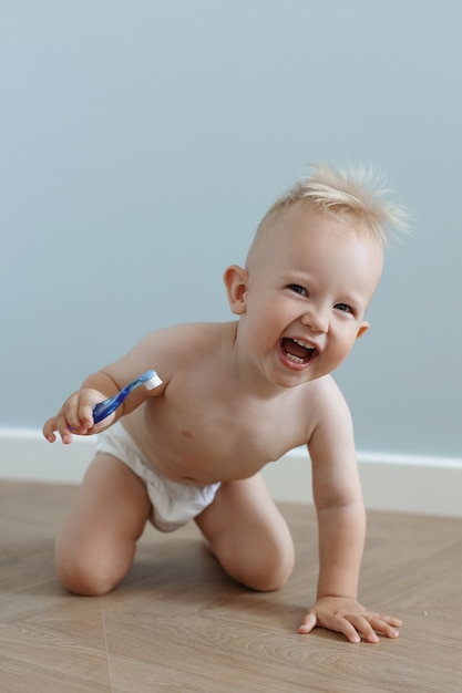 Little boy brushes his teeth with a toothbrush and laughs