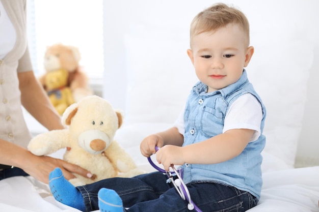 Photo little boy child with his mother at health exam at doctor's office