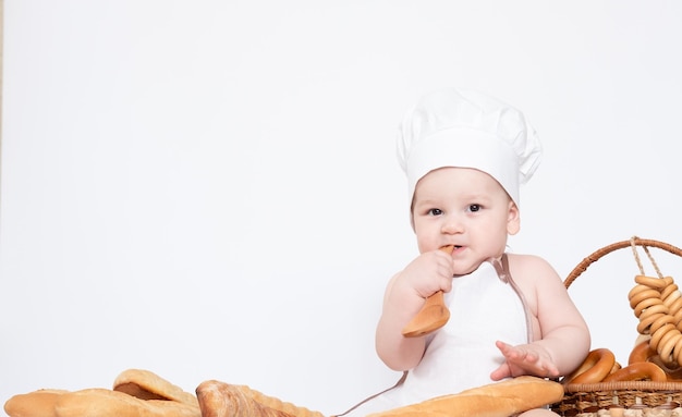 Little boy in a cook cap and with bread funny little chef