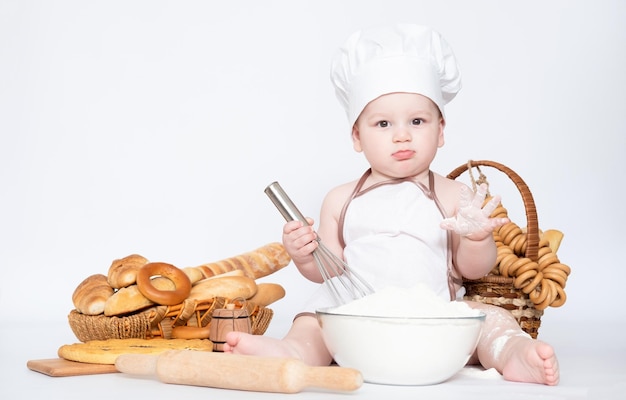 Little boy in a cook cap and with bread funny little chef