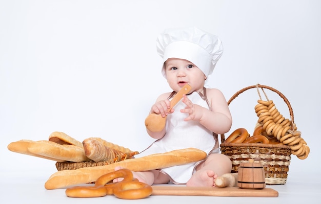 Little boy in a cook cap and with bread funny little chef