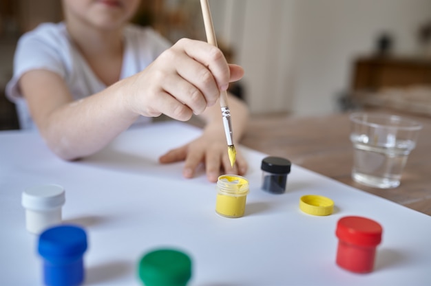 Little boy drawing with gouache, kids in workshop