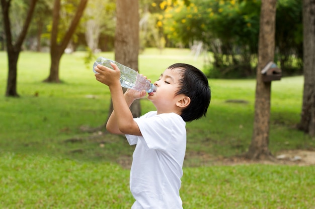 Little boy drink water at park outdoor