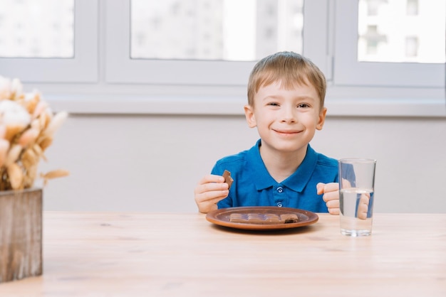 A little boy eats a chocolate bar he is in a good mood he is happy