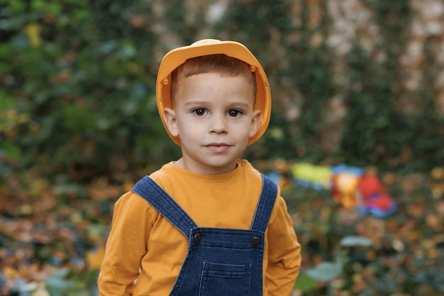 Little boy engineer builder architect with safety helmet on background construction crane on site