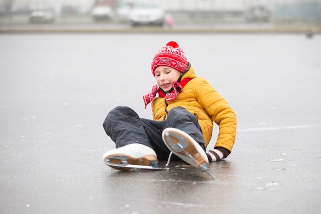 A little boy fell when he was learning to skateA child on an ice rink