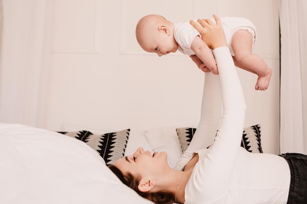 Little boy funny cute child, mother hold playing with son, toss the baby. Playful smiling laughing