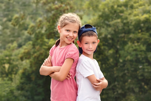 Little boy and girl stand with their backs to each other