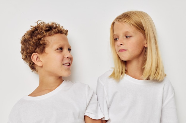 Little boy and girl in white Tshirts are standing next to Lifestyle unaltered