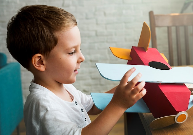 Little boy happily playing with his toy plane