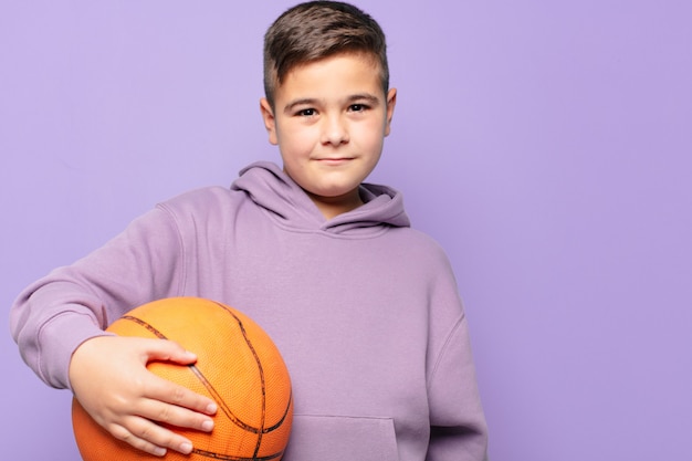 Little boy happy expression and holding a basketball ball