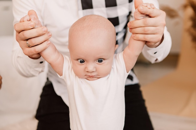 Little boy happy funny surprised cute child baby playing with parents, sitting on knees