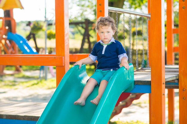 Little boy having fun on the slide on the playground