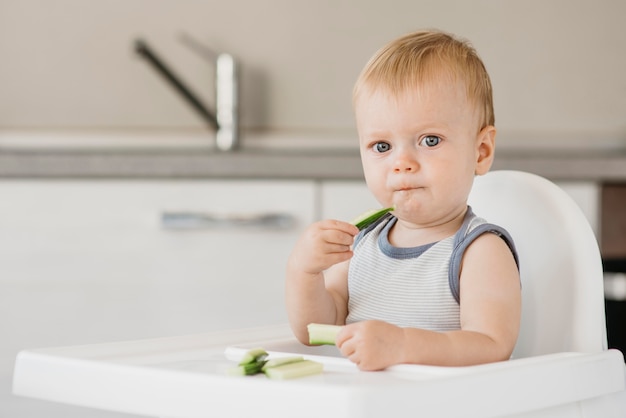 Little boy in highchair eating