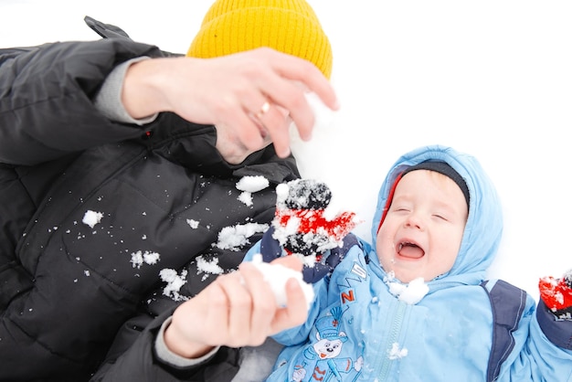 A little boy and his father playing in winter Outdoor recreation of a family with children in winter A child on a walk in a snowcovered winter park